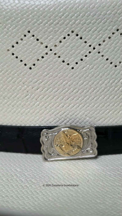 A close-up of a black leather belt with a decorative silver-toned rectangular buckle featuring a gold-toned coin insert, set against a white textured surface with a perforated diamond pattern.