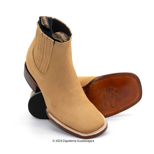 Tan cowboy boots with brown soles on a white background