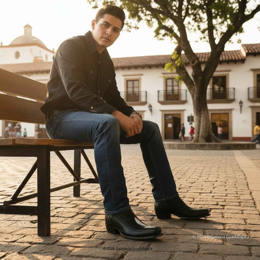 Man sitting on a bench in an outdoor setting with buildings and trees in the background