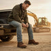 Man sitting on a truck bed with construction equipment in the background
