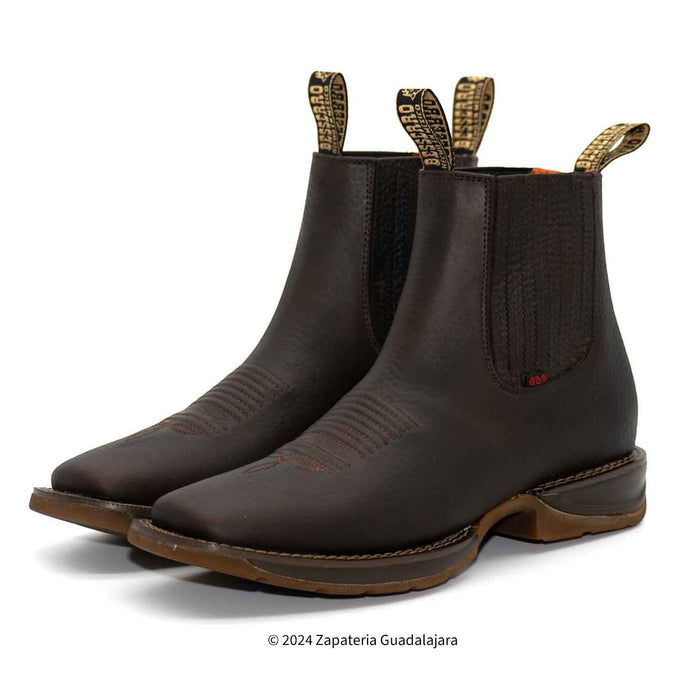 Pair of brown leather boots with elastic sides on a white background