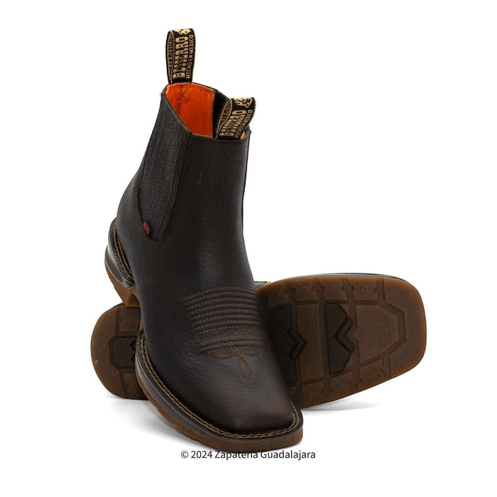 Pair of brown leather boots with a white background