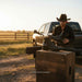 a pair fo cayman belly black leather boots with a cowboy with ahat in the background