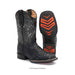 A pair of black western cowboy boots with a textured alligator or python-style embossed lower and white embroidered floral detailing on the shaft, shown on a white background with one boot displaying the sole's bright orange chevron tread.