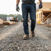 Person in work attire with a hard hat on a construction site
