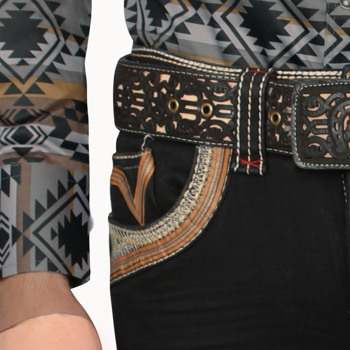 Close-up of a person wearing a patterned shirt with a black belt and embroidered details.