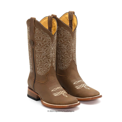 Brown cowboy boots with intricate white embroidery on a white background