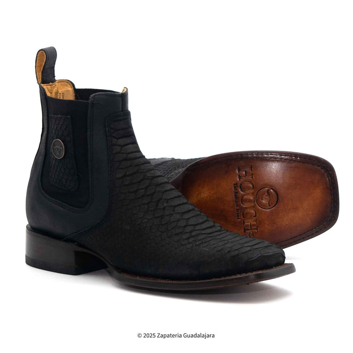 Black leather boot with brown sole on a white background