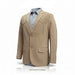 A tan suede blazer jacket with notched lapels and flap pockets, styled over a light blue dress shirt on a white background.