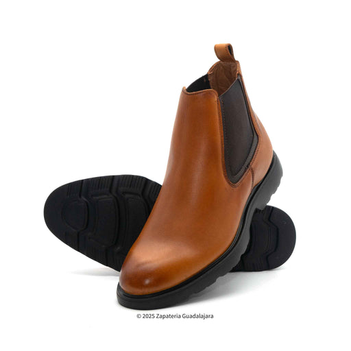 A pair of brown leather Chelsea boots with elastic side panels and a black pull tab on a white background.