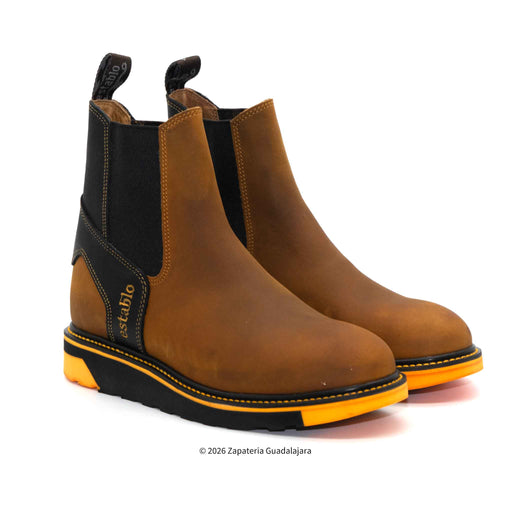Pair of brown Chelsea boots with black and orange accents on a white background