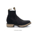 Black Chelsea boot with tan sole on a white background