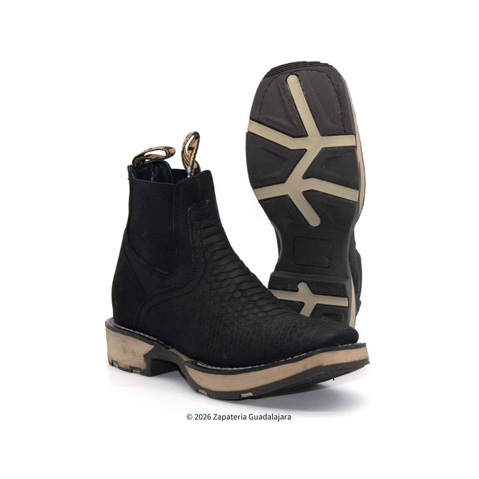 Black cowboy boots with tan soles on a white background