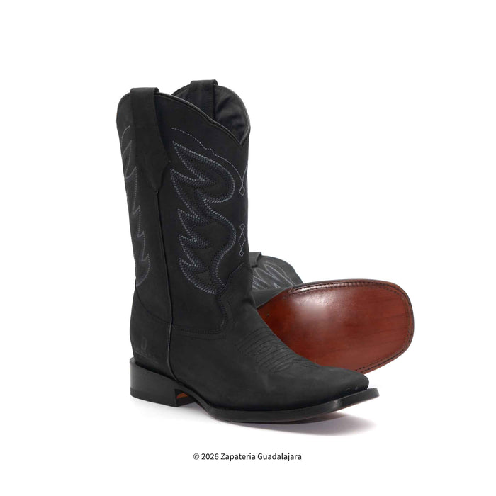 Black cowboy boot with brown sole on a white background