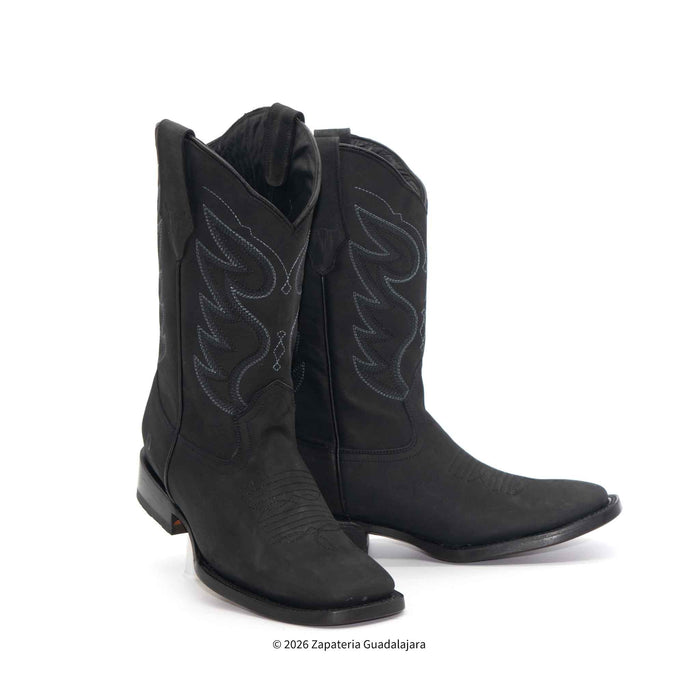Pair of black cowboy boots with white stitching on a white background