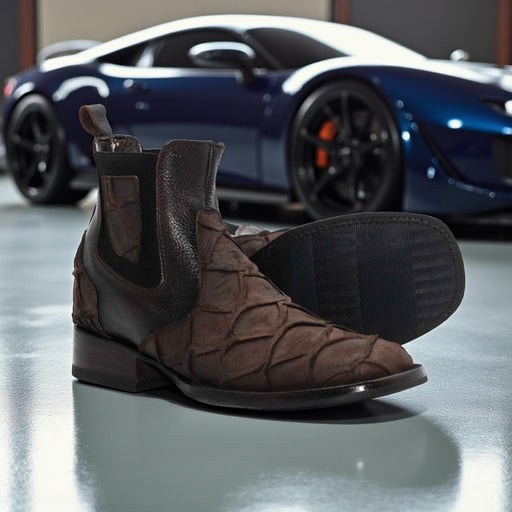 Brown suede shoes with black accents on a reflective surface, with a blue sports car in the background.