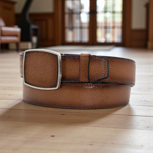 Brown leather belt with a silver buckle on a wooden floor.
