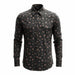 A long-sleeve button-up shirt with a black base and an all-over small skull print in brown and beige, displayed on a clean white background.