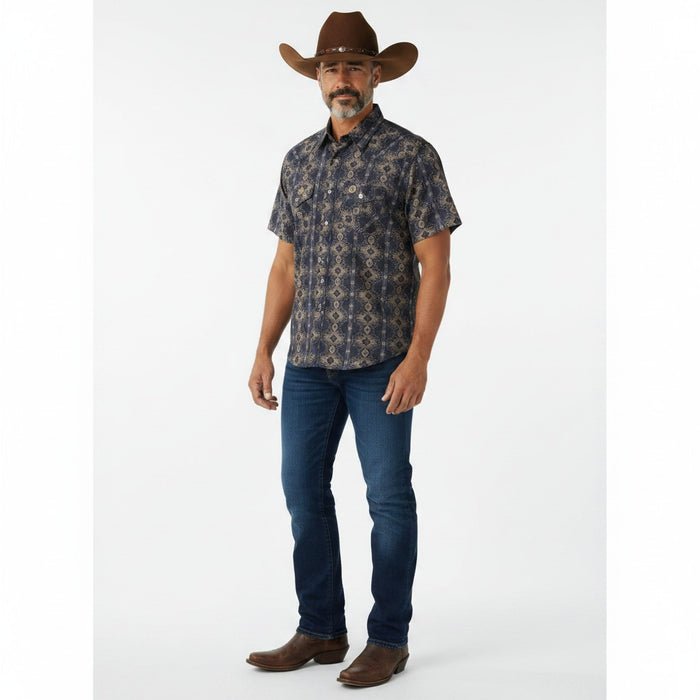 A man modeling a short-sleeve button-down shirt with a dark navy and brown geometric pattern, paired with blue jeans, brown cowboy boots, and a brown cowboy hat against a white studio background.