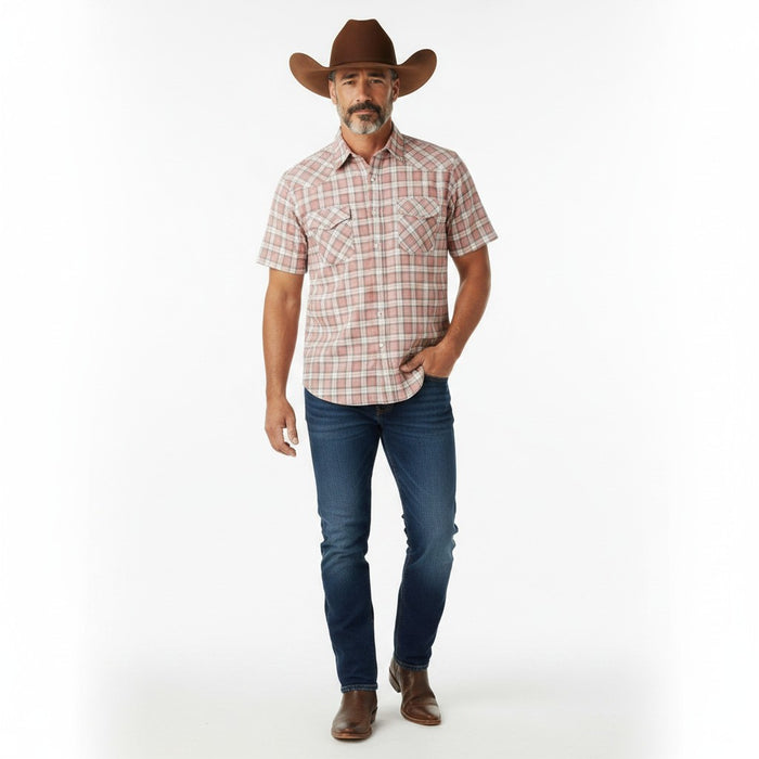 A man modeling a short-sleeve western plaid shirt, dark blue jeans, brown boots, and a brown cowboy hat against a plain white studio background.