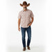 A man modeling a short-sleeve western plaid shirt, dark blue jeans, brown boots, and a brown cowboy hat against a plain white studio background.