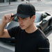 a young guy wearing a black cap wiith mexico emroidered with rhinestones