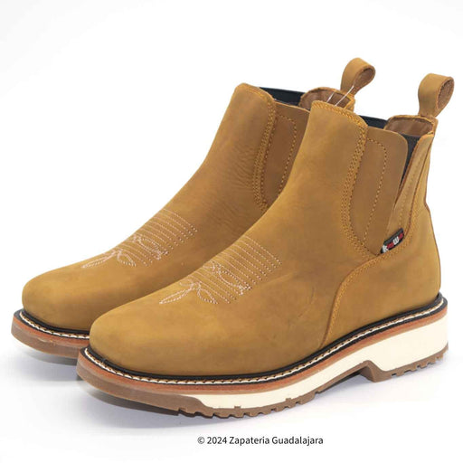Pair of tan Chelsea boots on a white background
