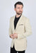 Man wearing a beige blazer over a black shirt on a white background