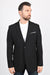 Man wearing a black blazer over a white shirt on a white background