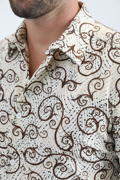 Close-up of a person wearing a patterned shirt with swirling designs.