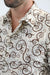 Close-up of a person wearing a patterned shirt with swirling designs.