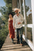 Man and woman walking on a wooden deck with trees in the background