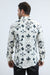 Man wearing a white shirt with black floral patterns on a white background