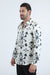 Man wearing a white shirt with black floral patterns on a white background