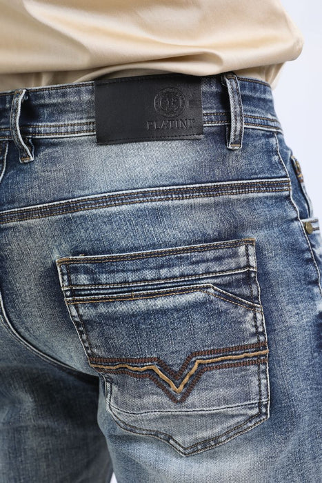 Close-up of blue jeans with a brand label on a white background