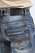 Close-up of blue jeans with a brand label on a white background