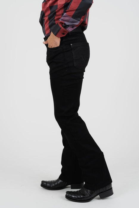 Person wearing black flared jeans with a red and black plaid shirt on a white background