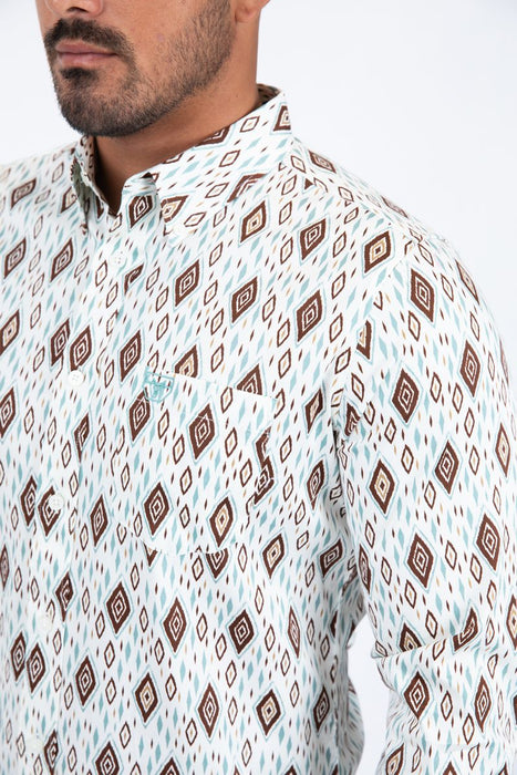 Man wearing a patterned shirt with a neutral background