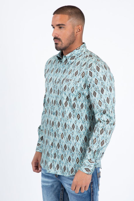 Man wearing a patterned shirt and jeans on a white background