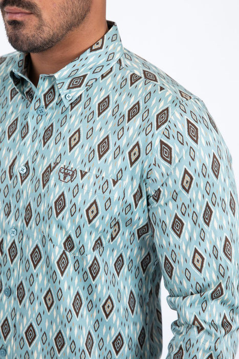 Man wearing a light blue patterned shirt with a collar.