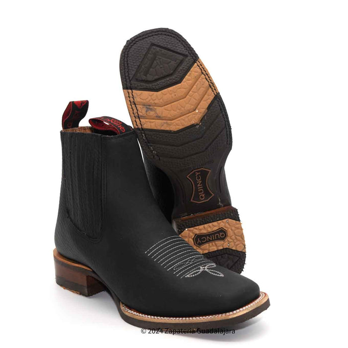 A pair of black charro boots with a wide square toe and rubber sole, made of genuine leather, displayed against a white background.