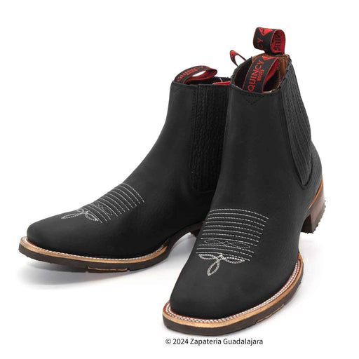 Black ankle boots with decorative stitching on a white background