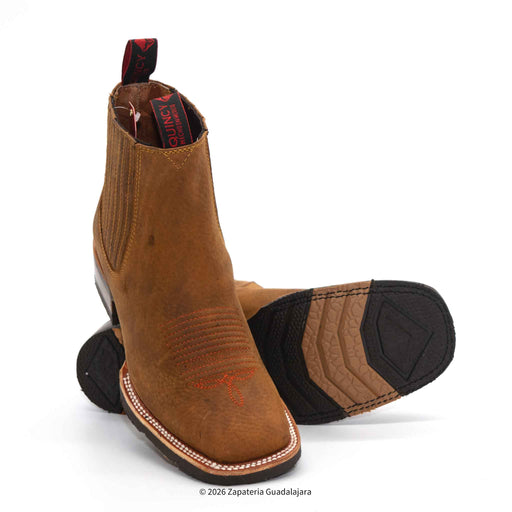 a pair of tan brown leather boots with rubber sole and white background