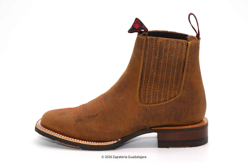 a pair of tan brown leather boots with rubber sole and white background