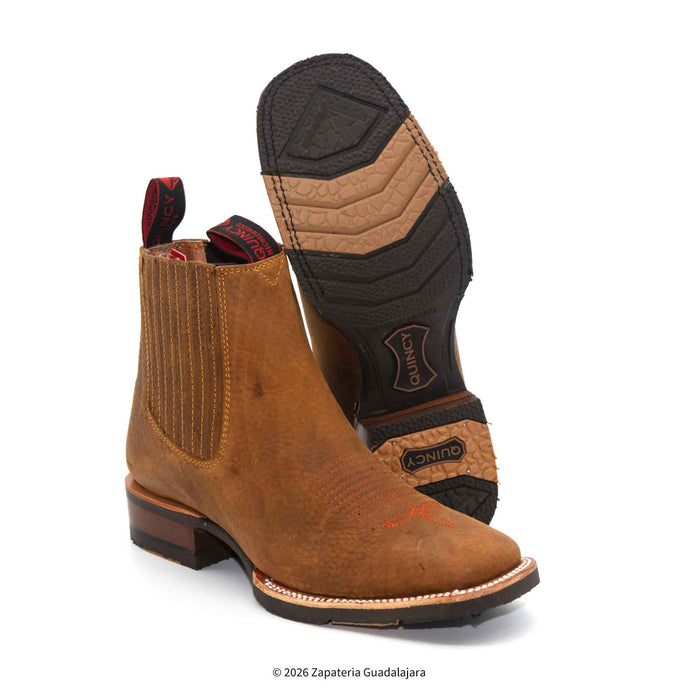 a pair of tan brown leather boots with rubber sole and white background