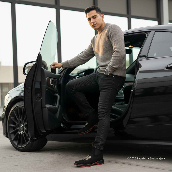 Man getting into a black car wearing black boots with red sole