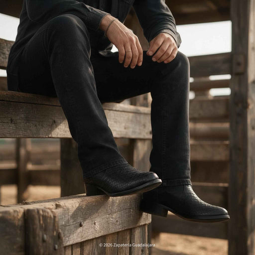 a man sitting wearing Roper RC5101-A black genuine python-print leather Western boots with side zipper