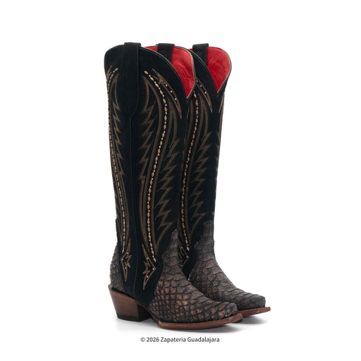 Pair of black and brown cowboy boots with red interior on a white background