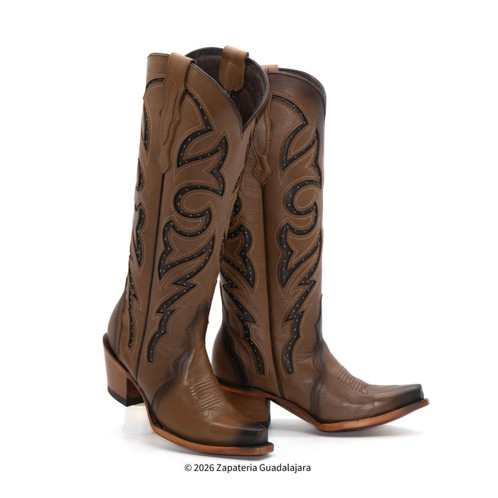 Pair of brown cowboy boots with intricate black designs on a white background