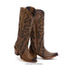 Pair of brown cowboy boots with intricate black designs on a white background